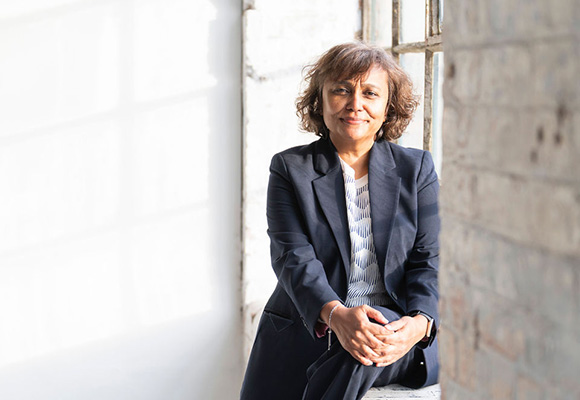 smiling woman in business attire sitting by window natural light 3 key insights in business strategy